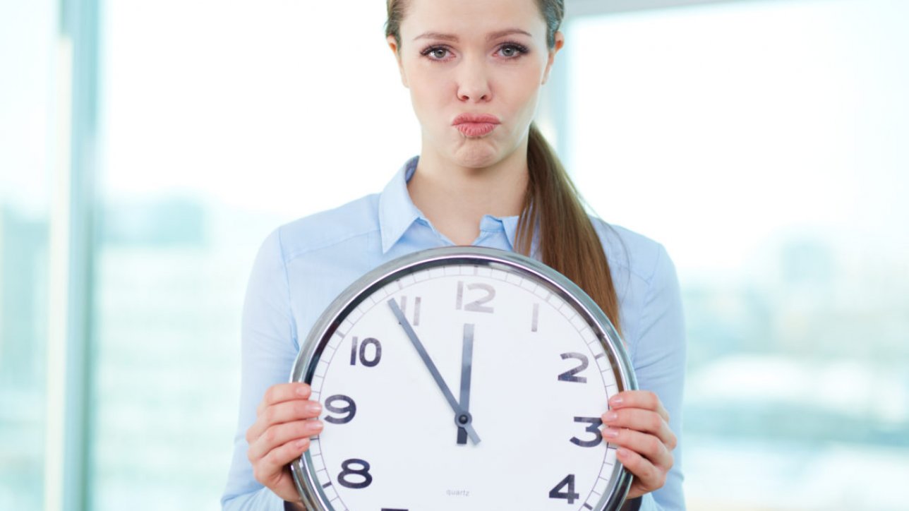 Conceptual portrait of a business lady with clock being short of time