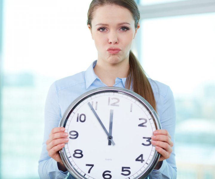Conceptual portrait of a business lady with clock being short of time